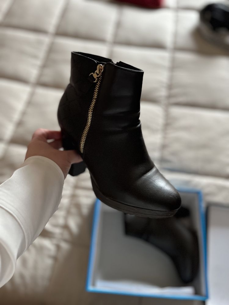 Botas pretas com fecho dourado