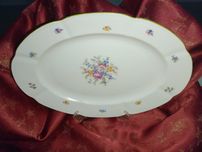 Półmisek porcelanowy w białym kolorze w kwiaty i z zieloną obwódką.