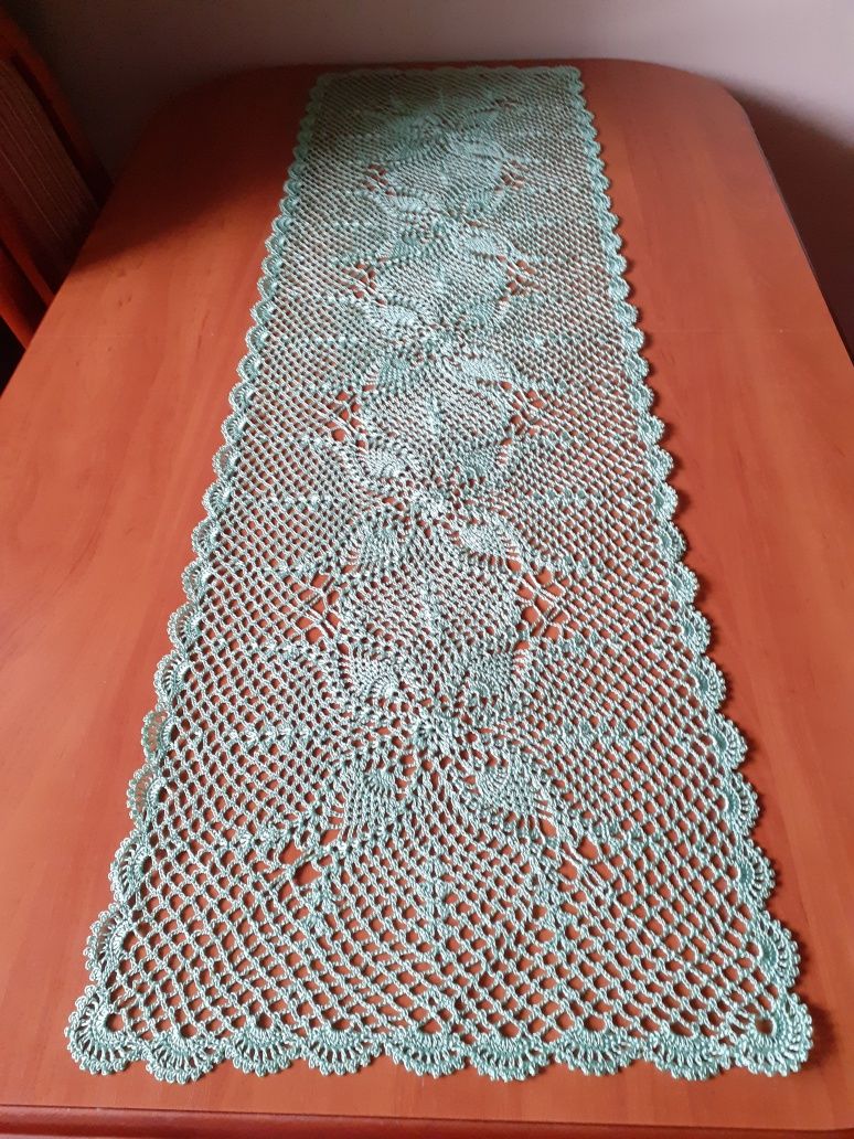Bieżnik na stół lub ławę w kolorze jasnej zieleni.