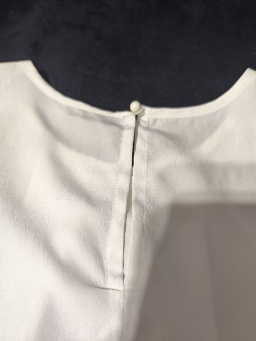 Przewiewna biała bluzka bez rękawów z marszczeniem