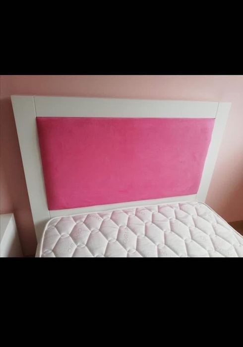 Cama de solteira com mesinha de cabeceira com duas gavetas.
