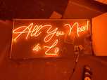 Letreiro em néon laranja "All you need is love"