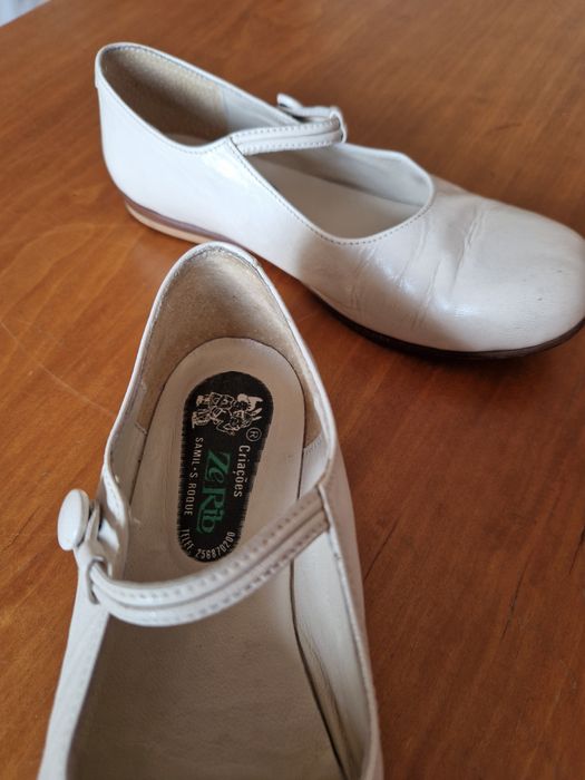 Sapatos de menina de cor bege.