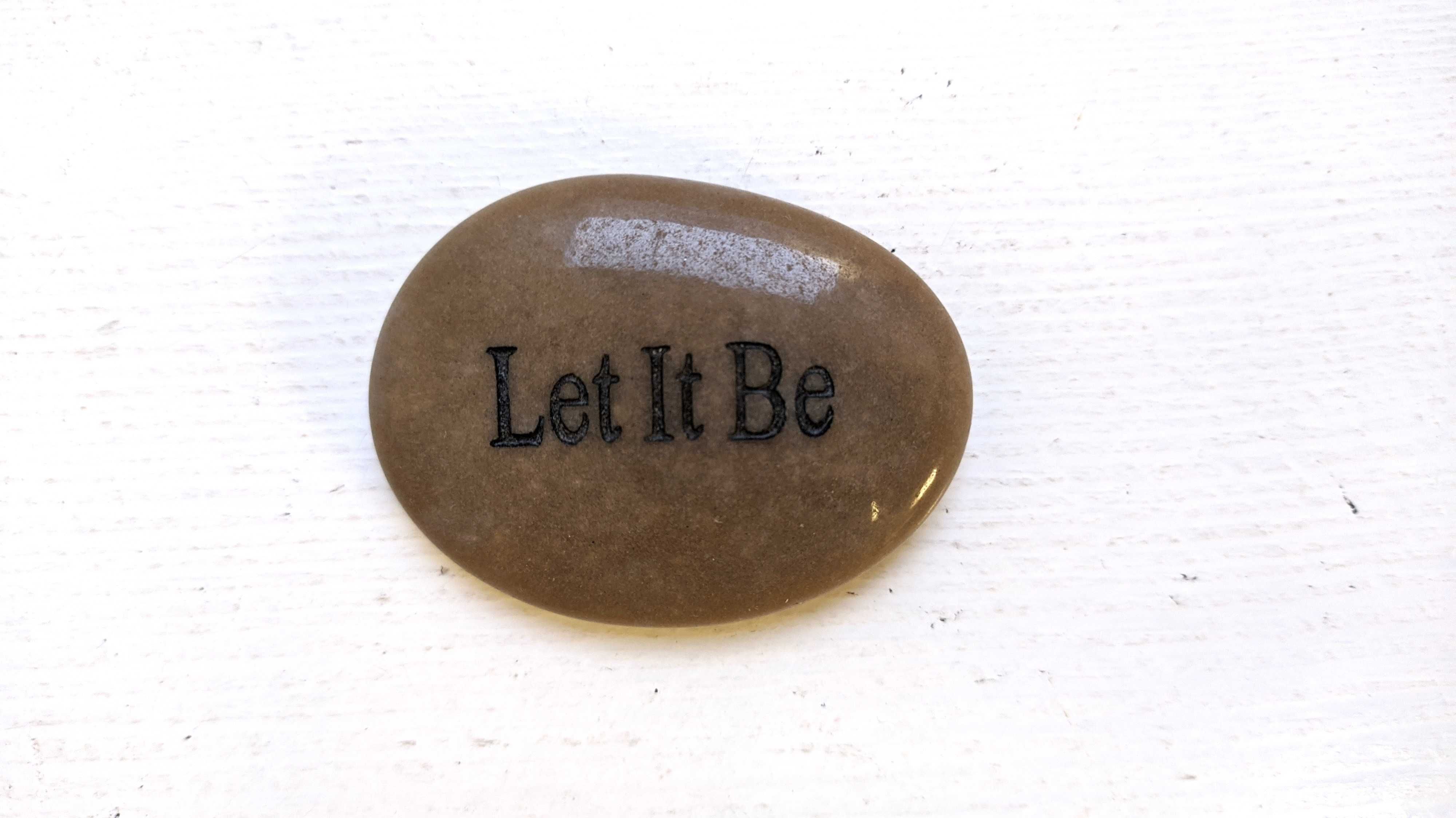 Płaski owalny kamień z wyrzeźbionym napisem "Let it be". 5 cm