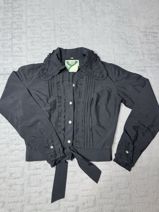 Чорна блузка з рюшами та зав'язками на талії.