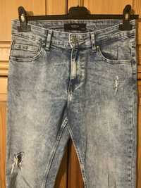 Spodnie jeansy z przetarciami Reserved