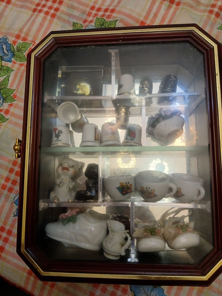Expositor com colecao de dedais e porcelanas