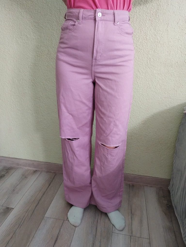 Różowe spodnie jeansowe z dziurami.