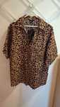 Camisa de manga curta com padrão leopardo.
