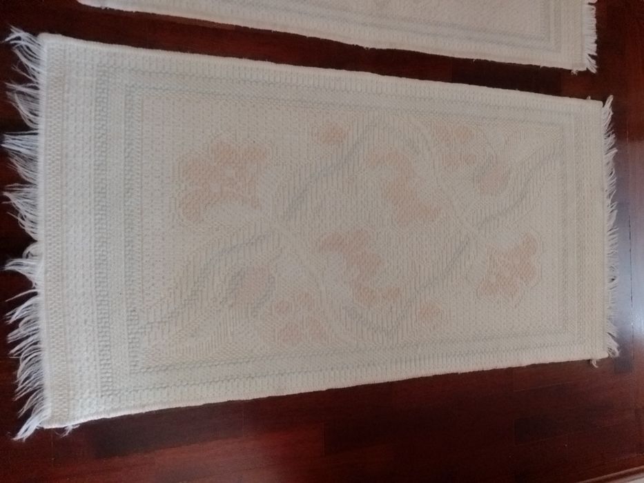 Três tapetes em branco e rosa.
