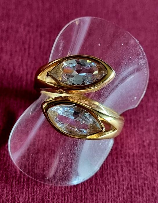 Anel dourado, em aço, com 2 pedras de vidro transparentes. T19