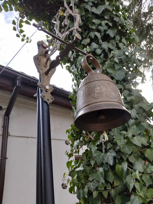 stary dzwon mosiężny , wiszący na stelażu