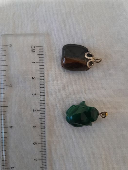 Dwie zawieszki z kamienia. Zielona w kształcie żaby i brązowo czarna .