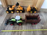 Pojazdy budowlane JCB i traktor z przyczepą.