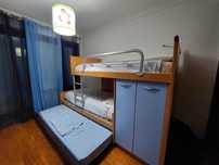 Quarto com três camas, comodas, guarda roupas e estantes