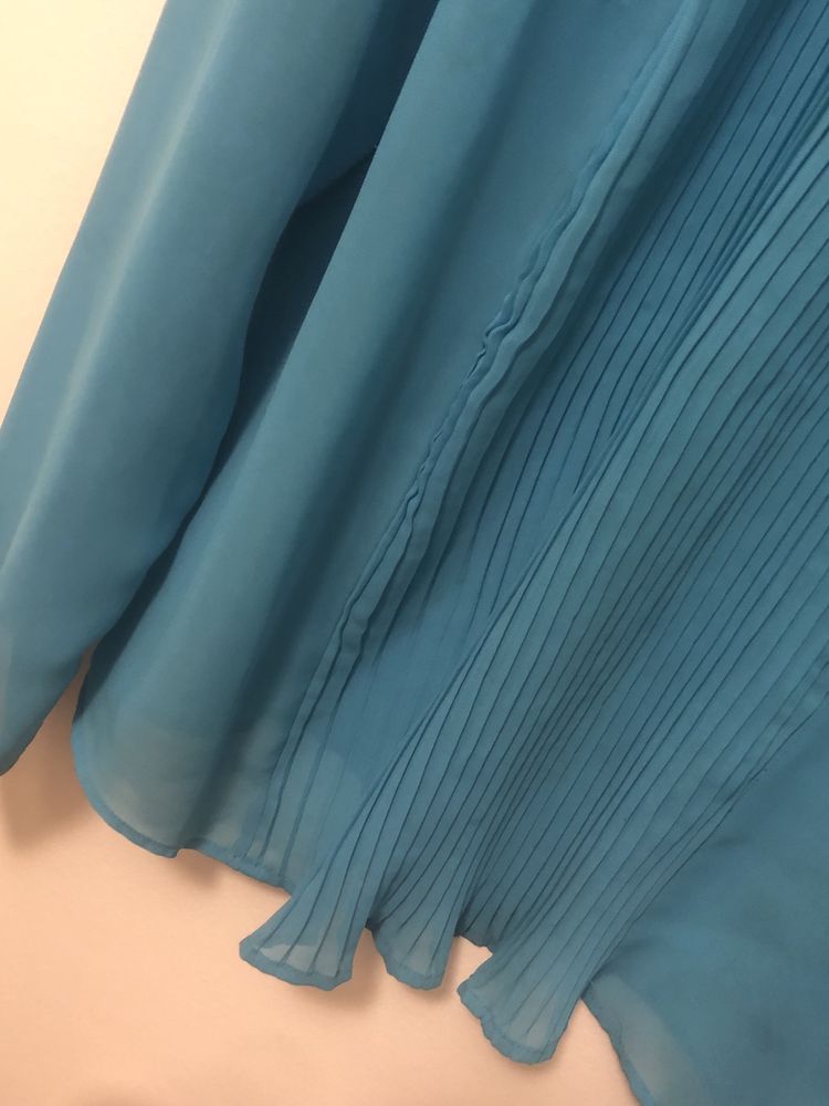 Camisa azul turquesa tamanho L com pormenor de plissado na frente.
