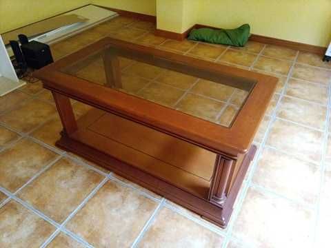 Mesa de madeira com tampo de vidro.