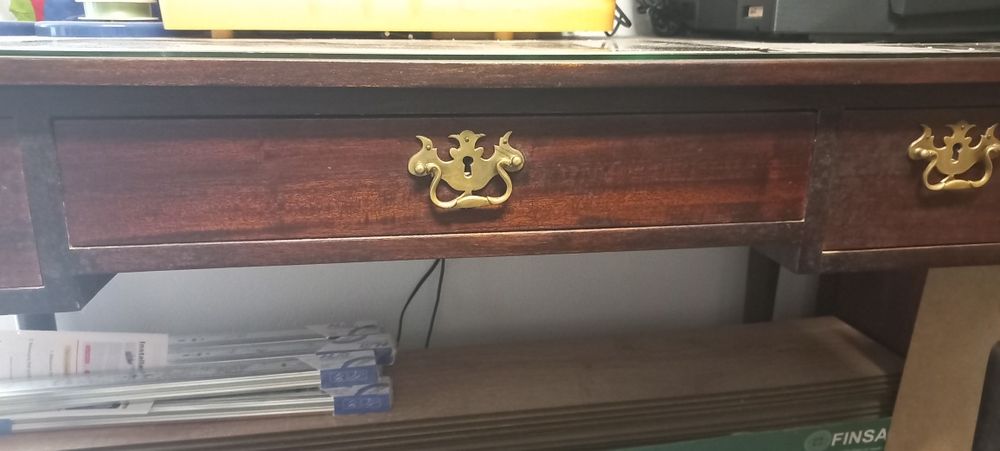 Mesa com três gavetas e tampo de vidro