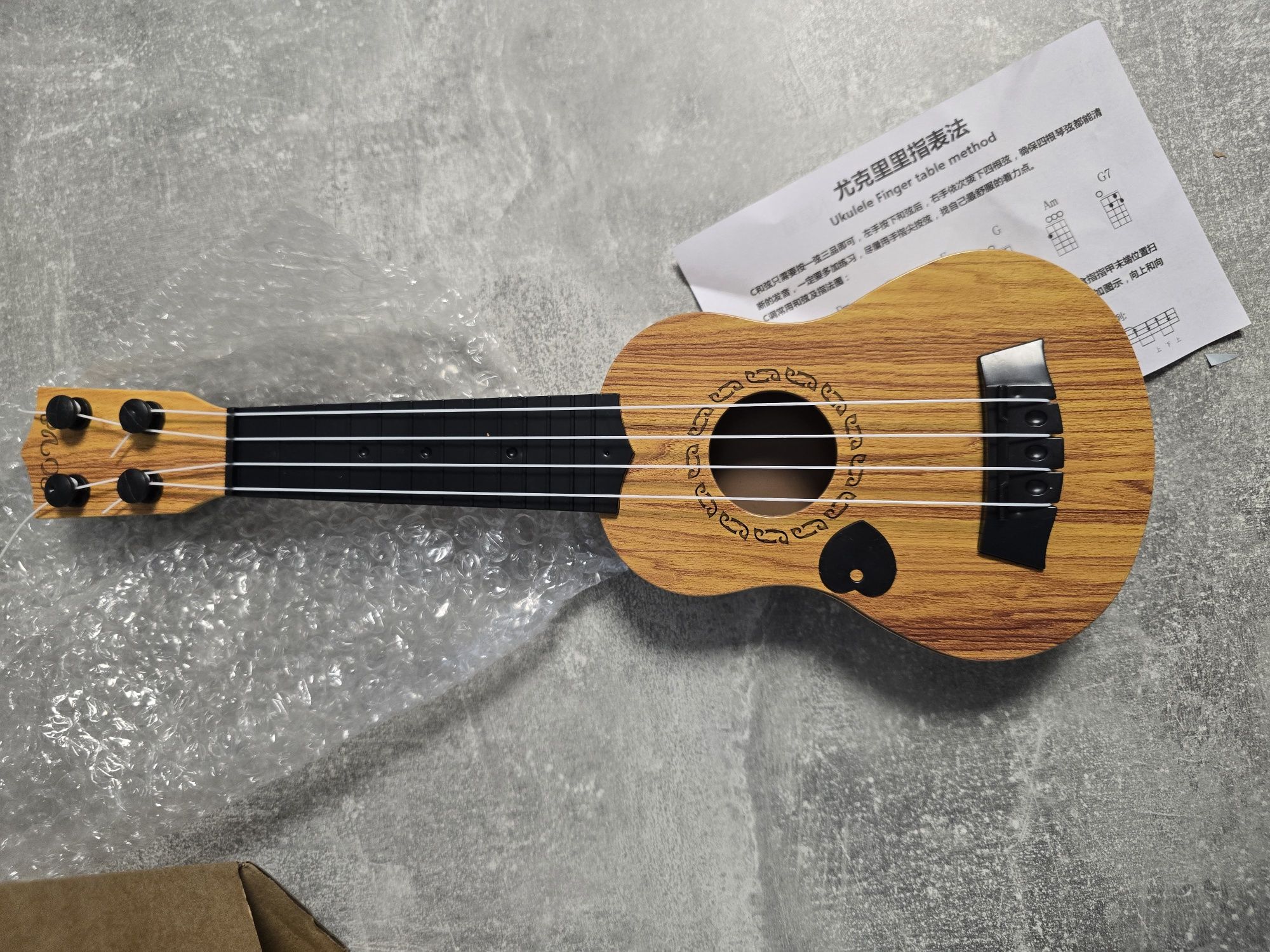 Ukulele zabawka dla dzieci 35 cm z kostką i strunami