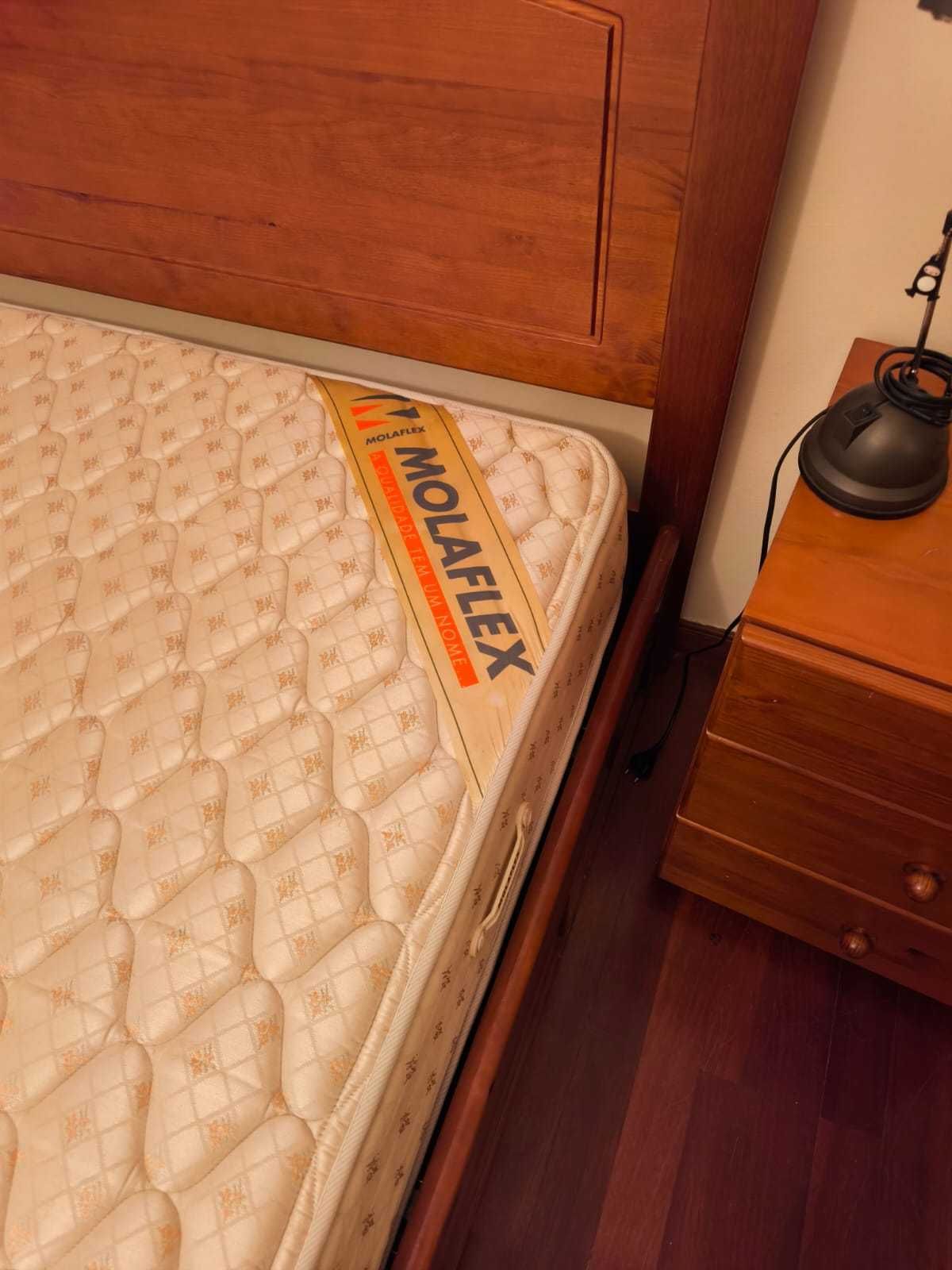Quarto de casal com cama, colchão e mesinha em pinho mel