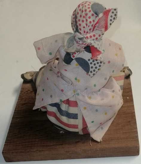 Boneca tradicional africana com trajes do campo num suporte de madeira