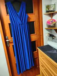 Długa niebieska sukienka brokatowa z paskiem.