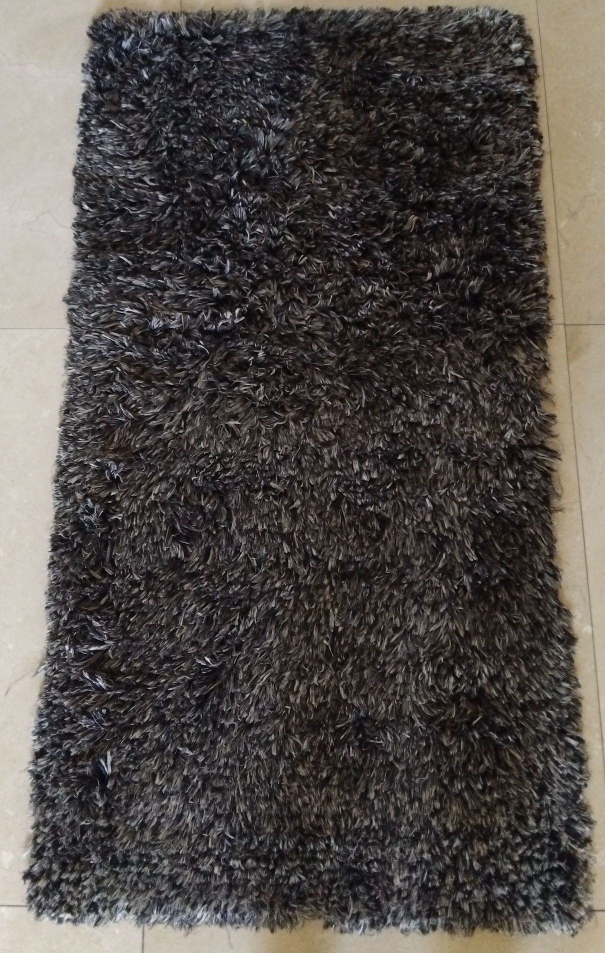 Tapete cinzento com pelos e relevo