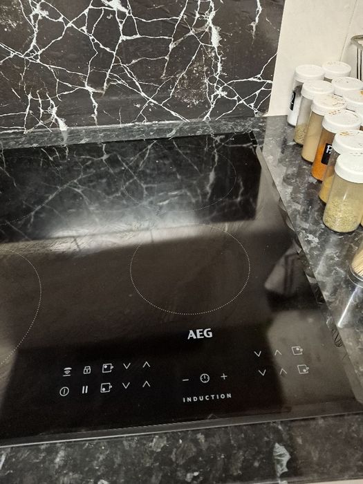 Fogão de indução marca AEG de cor preta com 4 bocas redondas