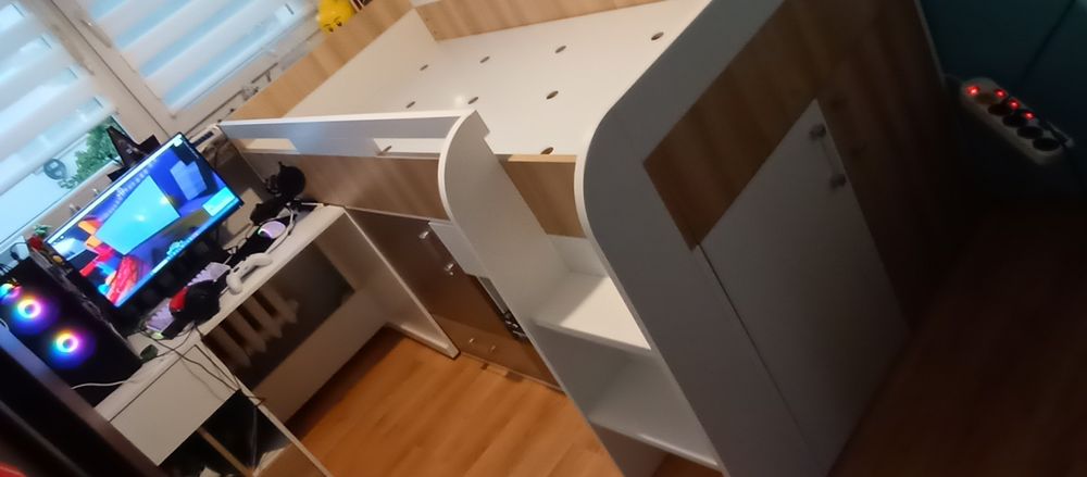 Łóżko dziecięce z szafką, szufladami, półkami i biurkiem.