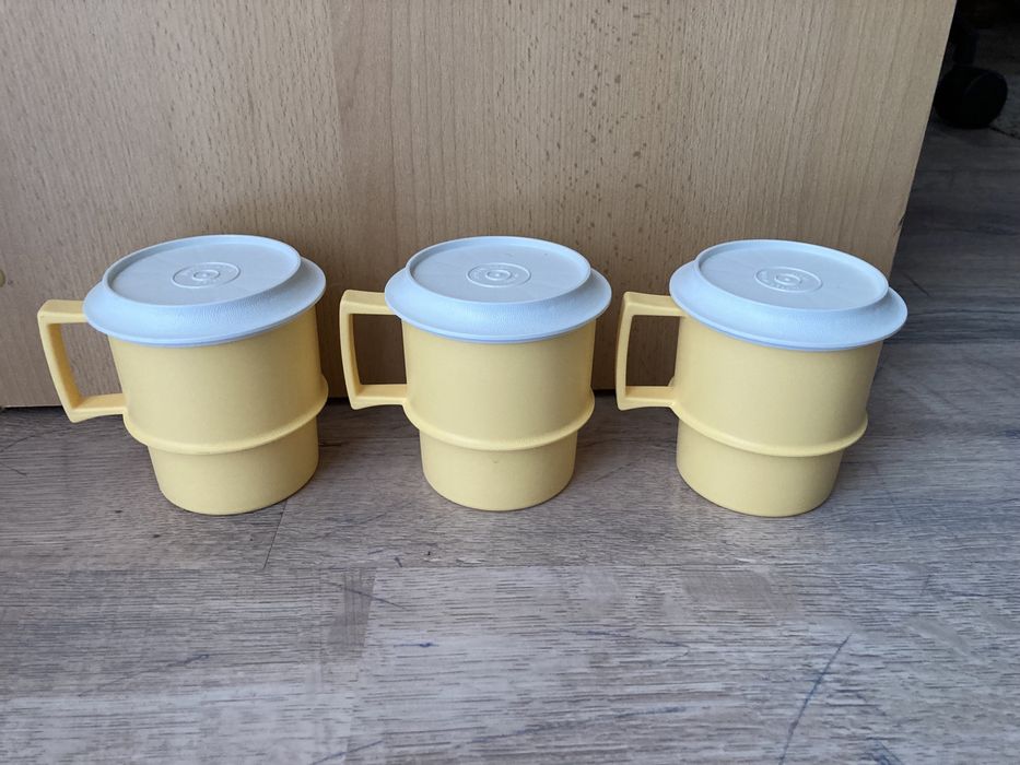 Trzy kubki plastikowe z pokrywkami tupperware