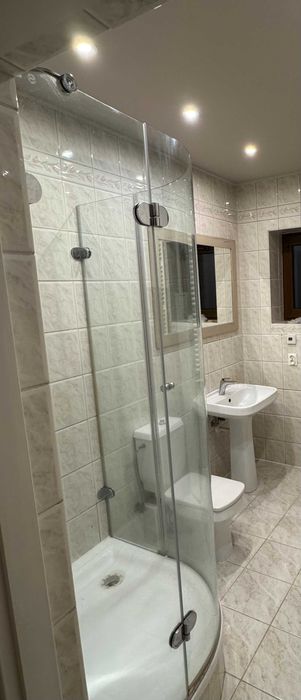 Kabina prysznicowa z brodzikiem  i umywalka oraz grzejnik łazienkowy