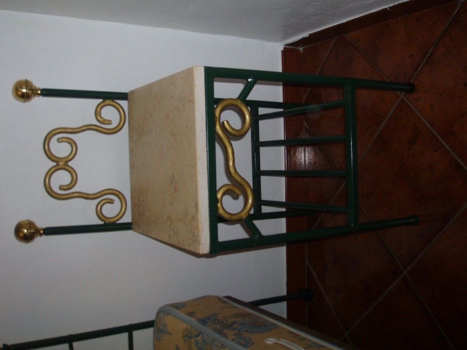 cama de ferro com mesa de cabeceira e candiero de teto