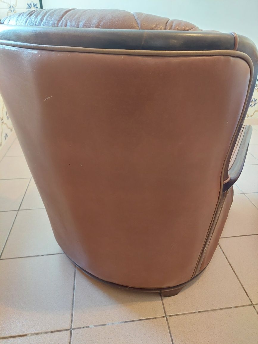 Sofá individual em pele castanha.