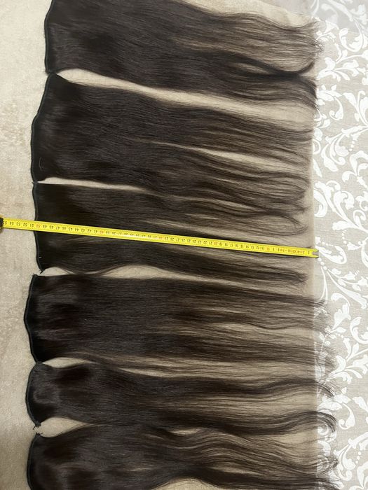 Extensões castanhas escuras de cabelo verdadeiro.