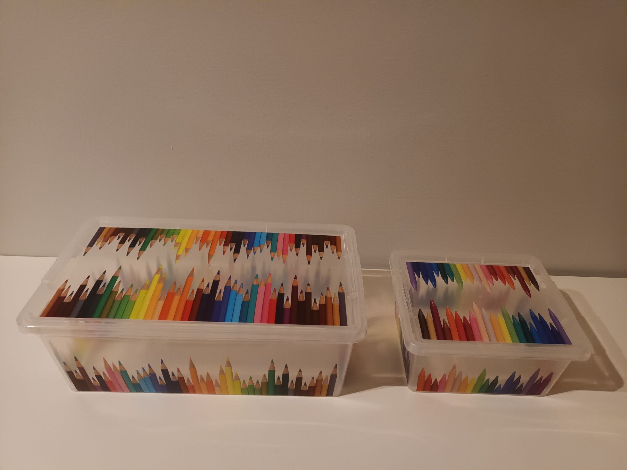Caixas plásticas com lápis desenhados