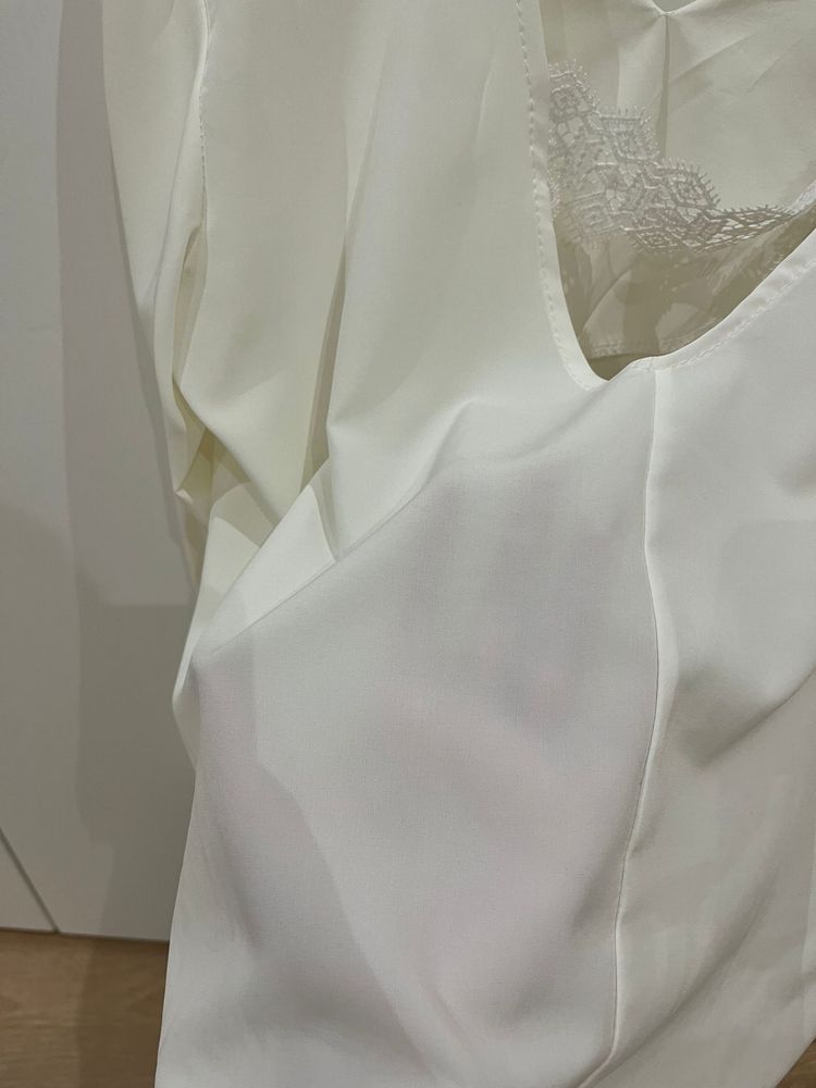 Blusa branca de manga comprida com elasticos na manga e costas abertas