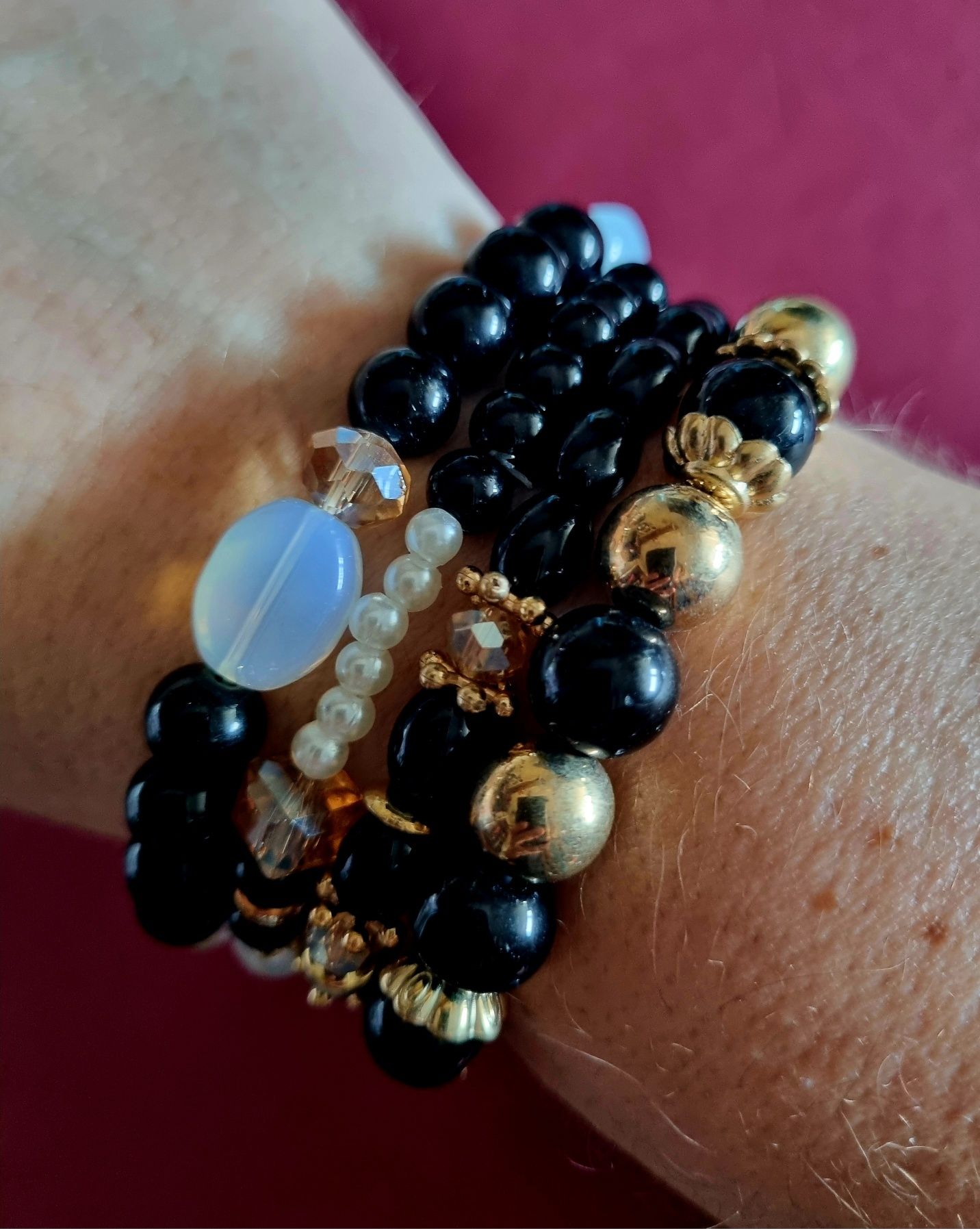 Conjunto de 4 pulseiras elásticas em tons de preto e dourado.
