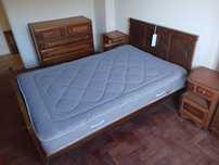 Quarto casal com cama, duas mesinhas cabeceira, uma cómoda e roupeiro.