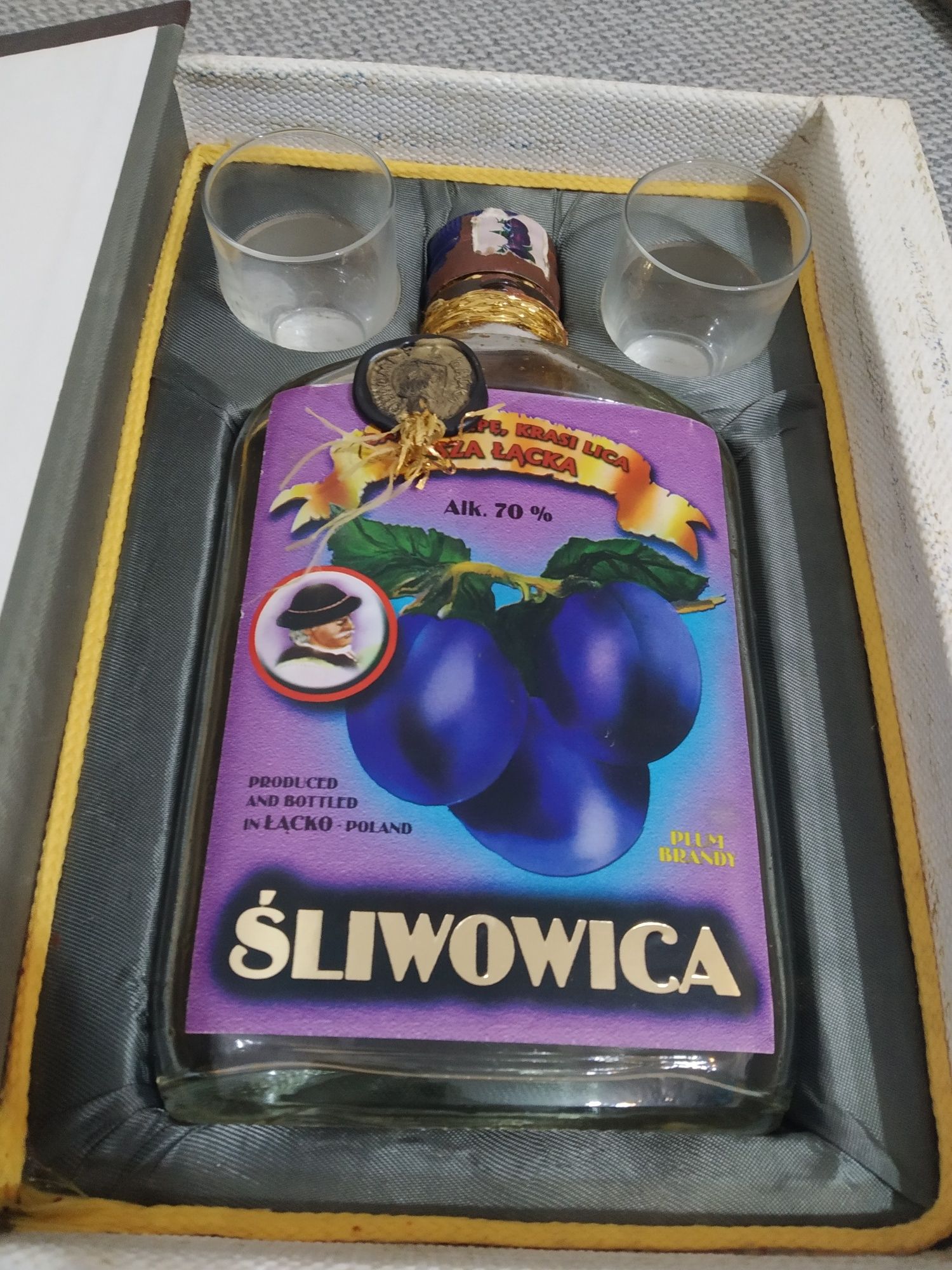 Książka schowek na alkohol z kieliszkami i butelką śliwowica