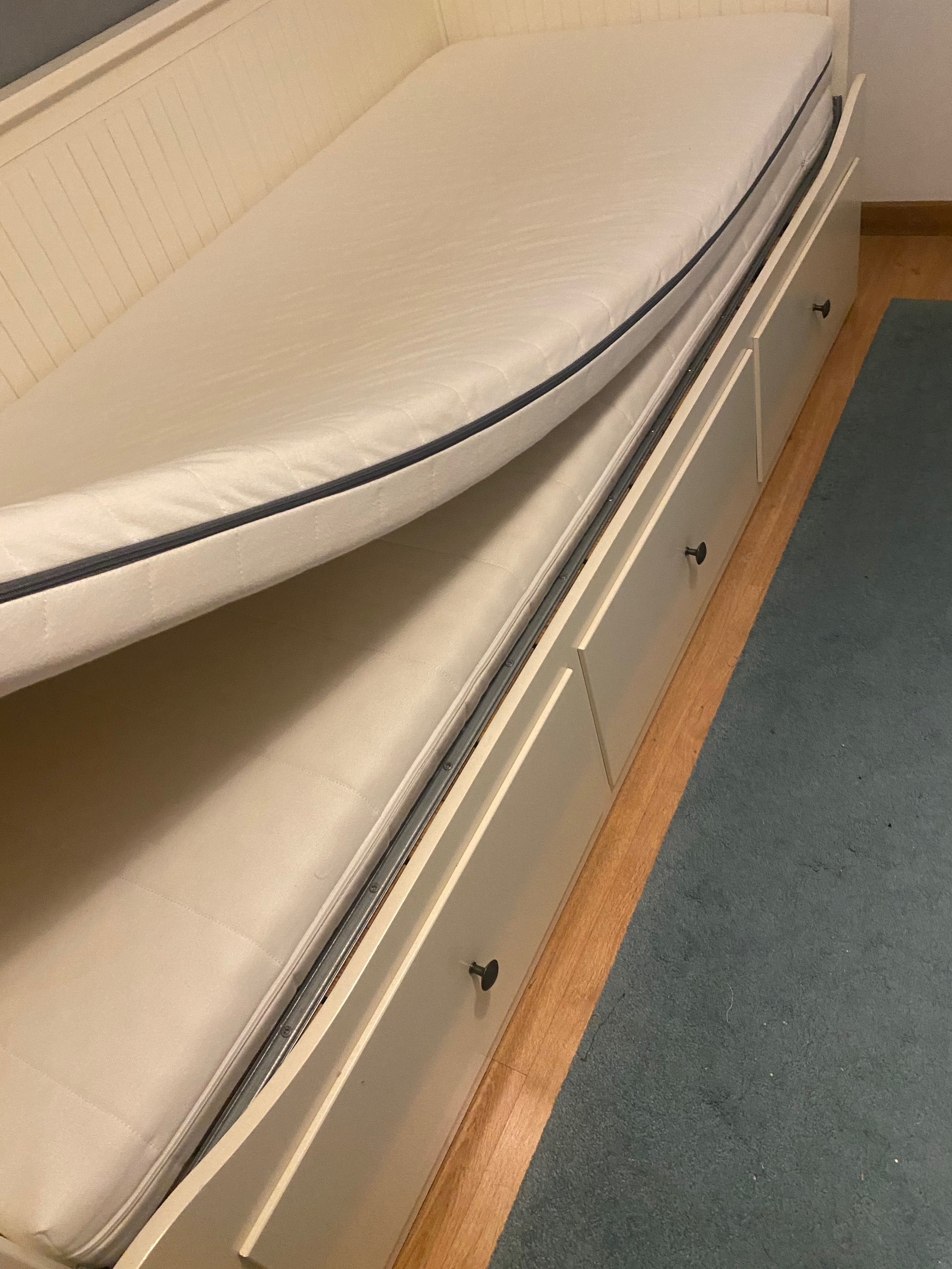 Um sofá, uma cama individual, uma cama de casal e arrumação