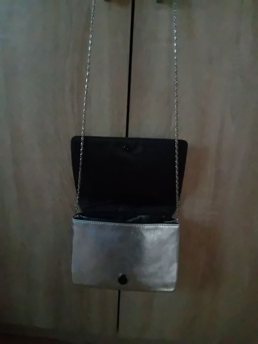 Torebka damska koloru srebrnego z z dłuszym paskiem srebrnym.