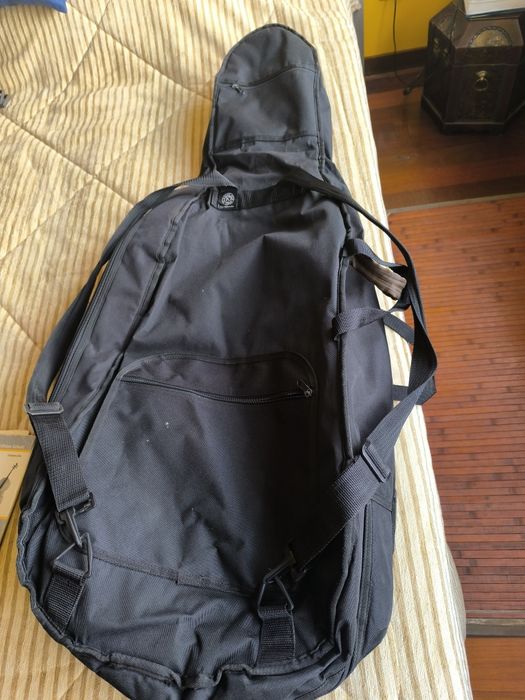 Capa para violoncelo, arco e livros diversos