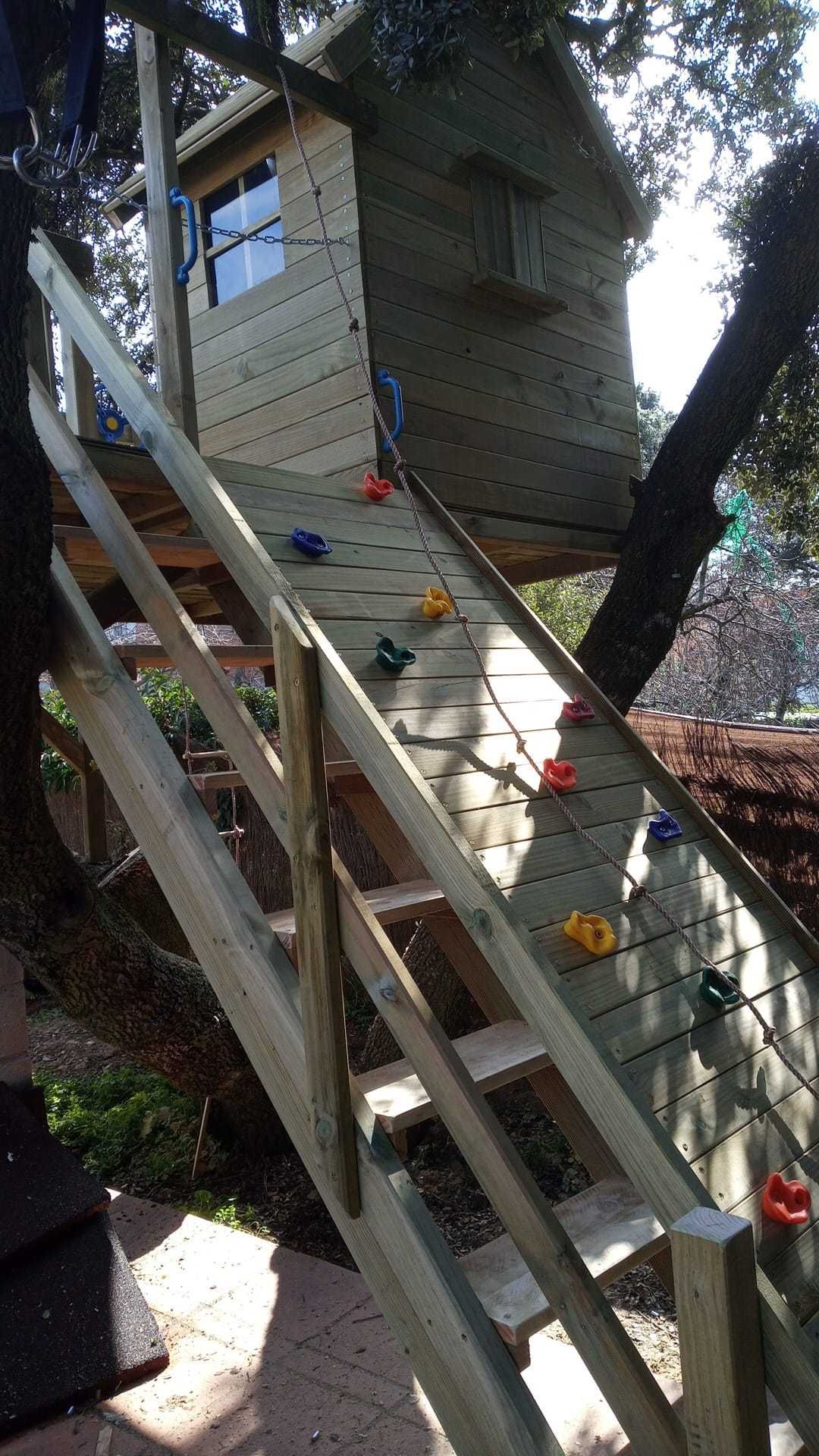 Casinha na árvore com parede de escalada