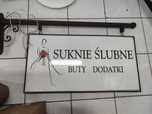 Szyld "Suknie Ślubne Buty Dodatki" po likwidacji salonu.