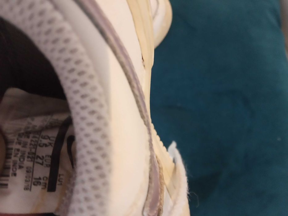 Sapatilhas de criança brancas da marca Nike com algumas marcas de uso.