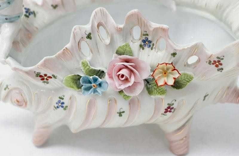 Taça em porcelana modelada em forma de búzio com querubins e flores