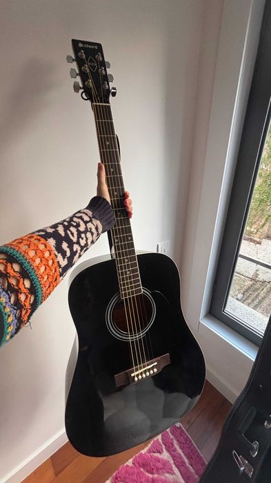 Violão acústico preto elegante com estojo rígido combinando.