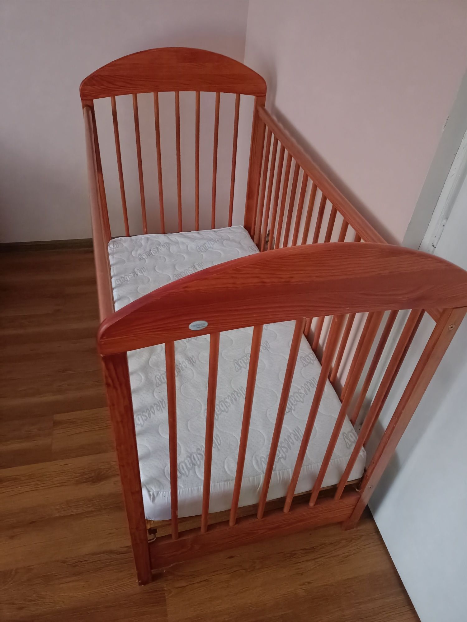Drewniane brązowe łóżeczko dziecięce z materacem