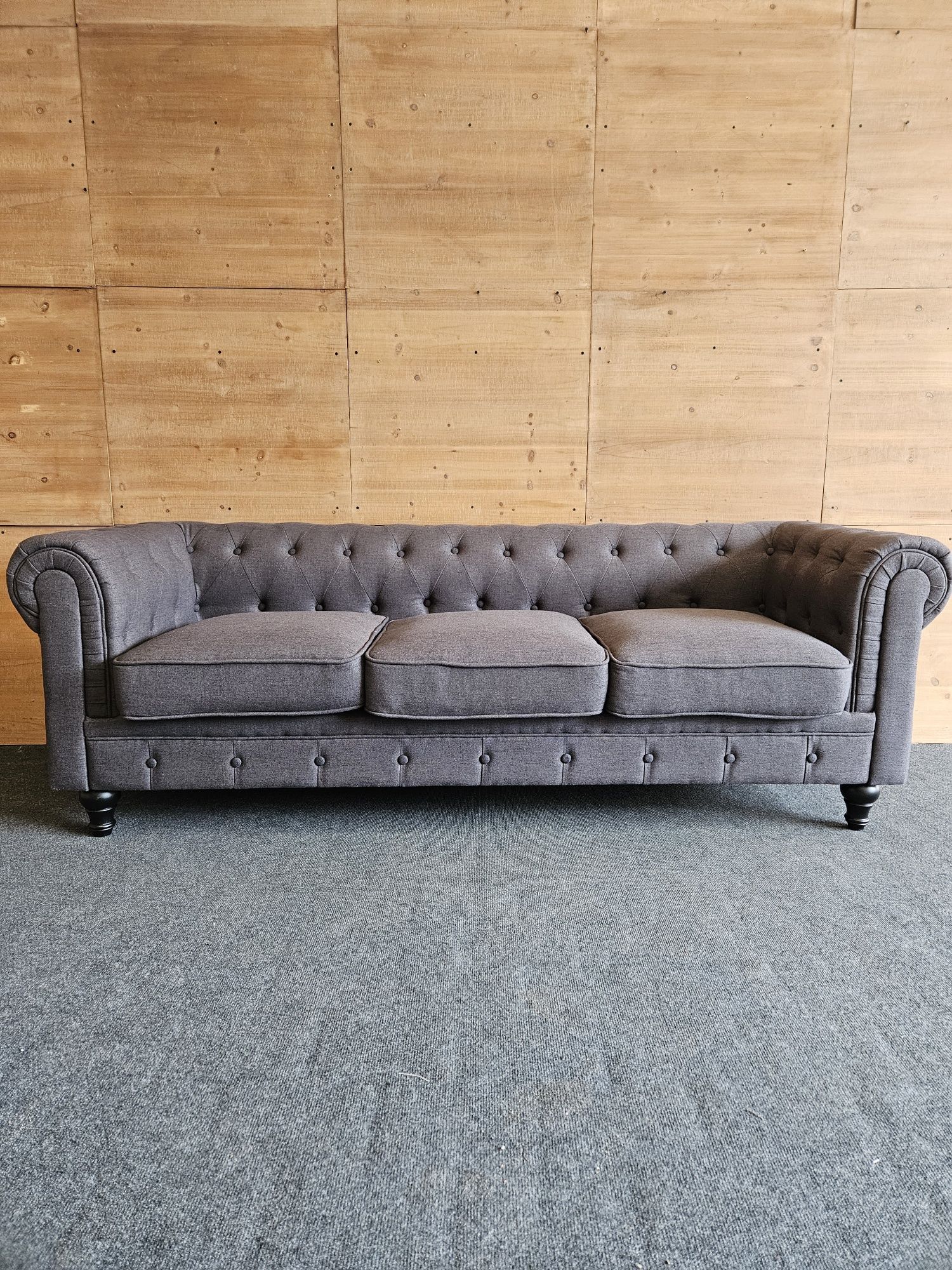 Szara materiałowa sofa Chesterfield