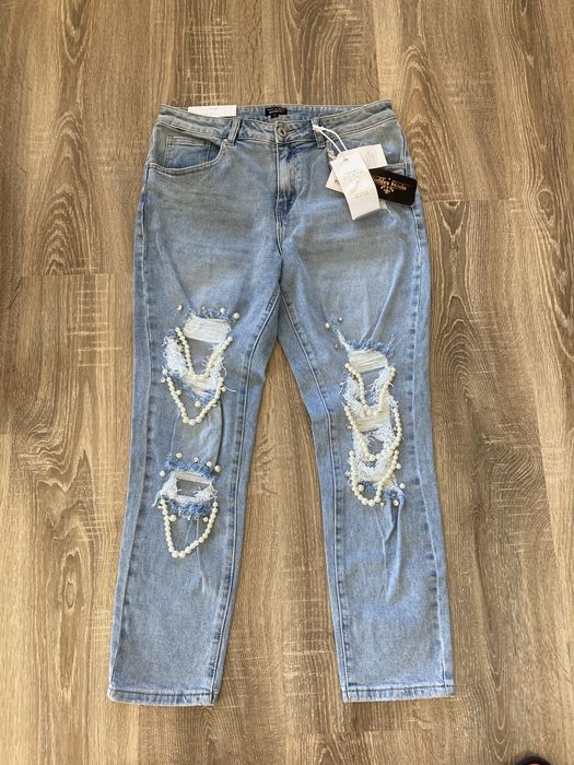 Spodnie z dziurami i perłami